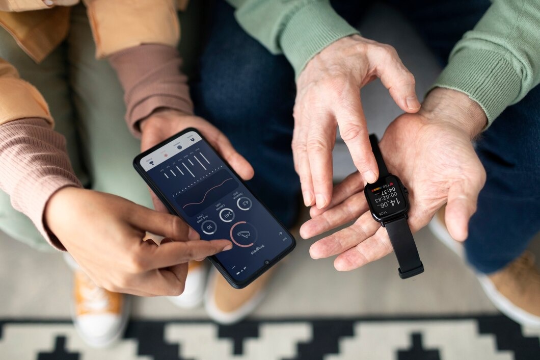 A man and woman are smiling while holding their smart watches, showcasing the devices on their wrists